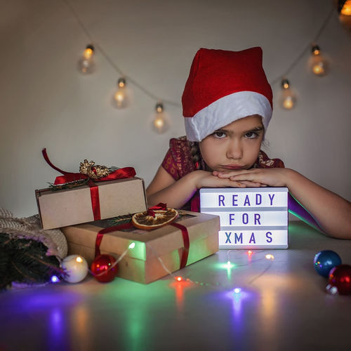 Portrait of smiling boy with christmas decorations on table