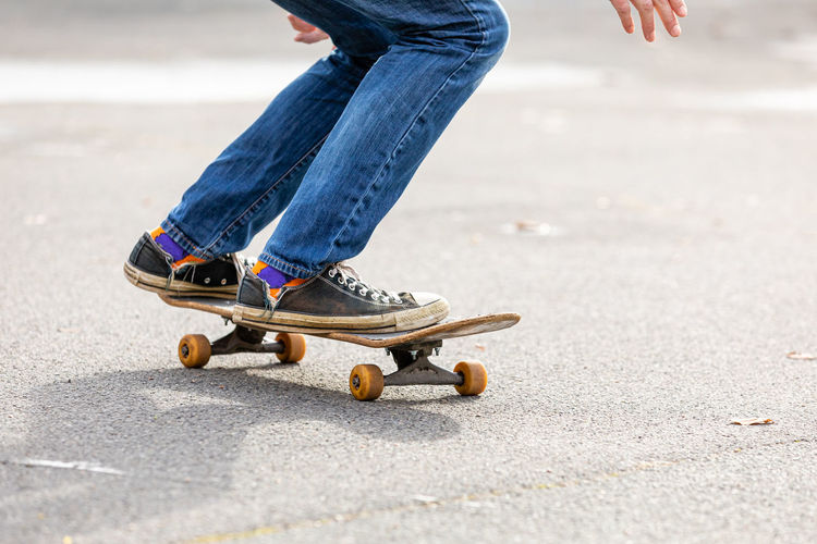 Low section of man skateboarding on road