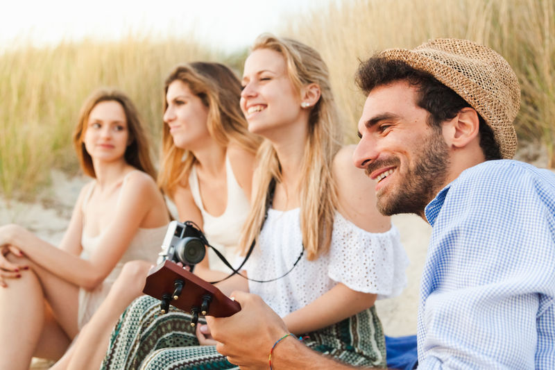 Cheerful friends spending leisure time on beach