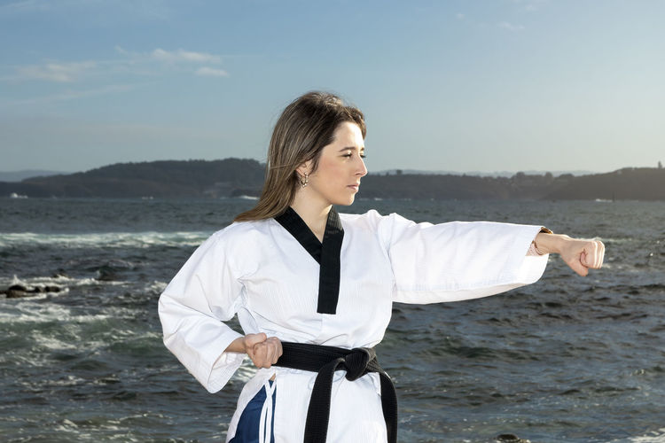 Woman in kimono doing martial arts on the beach