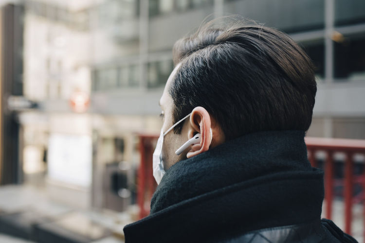 Male entrepreneur with wireless in-ear headphones
