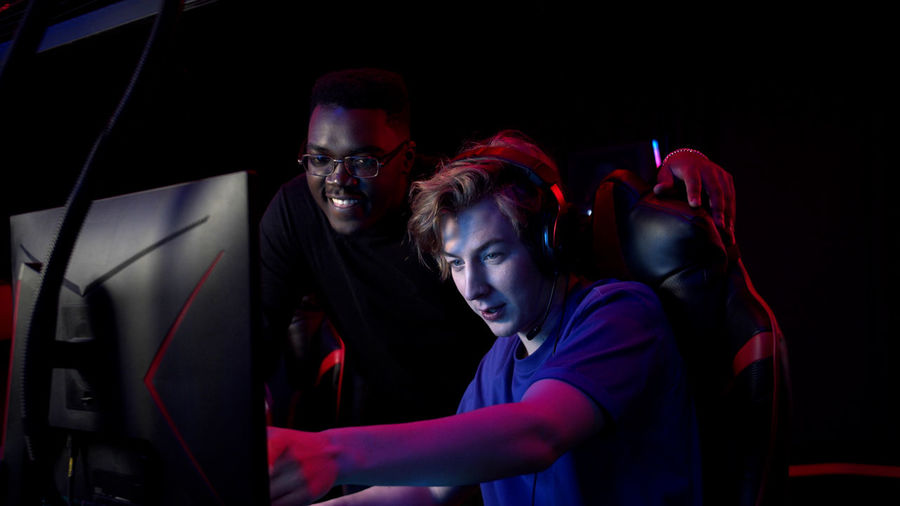Men playing video game in darkroom