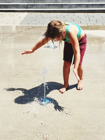 Playful girl at water fountain