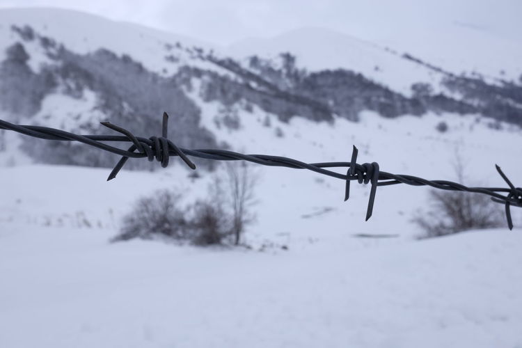 Close-up of barbed wire on snow