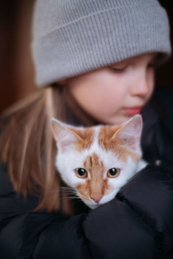 Close-up of young woman with red cat