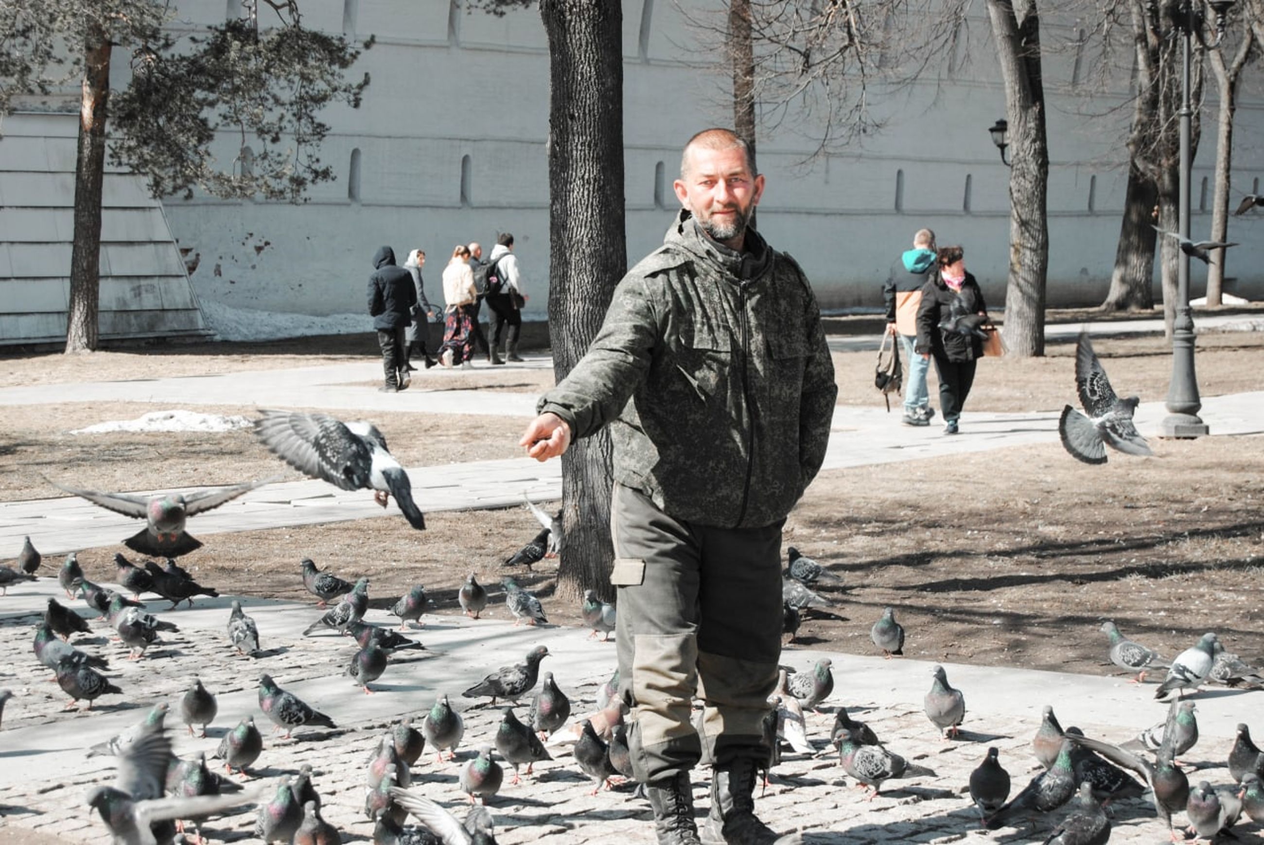 bird, men, adult, pigeons and doves, winter, animal, full length, architecture, pigeon, day, nature, government, city, animal themes, outdoors, street, one person, large group of animals, troop, clothing