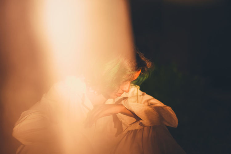 PORTRAIT OF WOMAN STANDING AGAINST CURTAIN