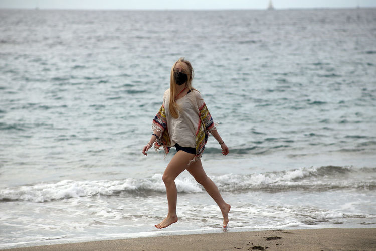 Side view of woman walking at beach
