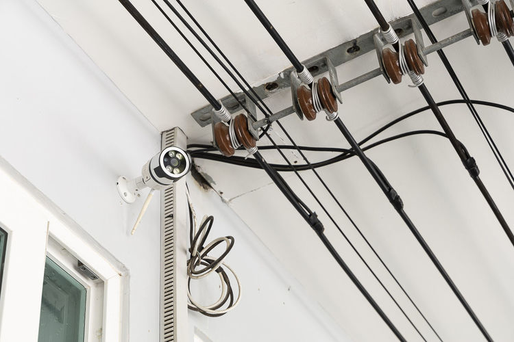 Cctv mounted on the front wall of a house. and main cable for power supply.