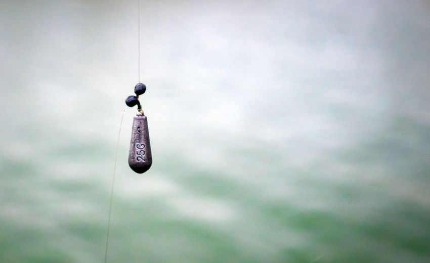 Low angle view of toy hanging on rope against sky