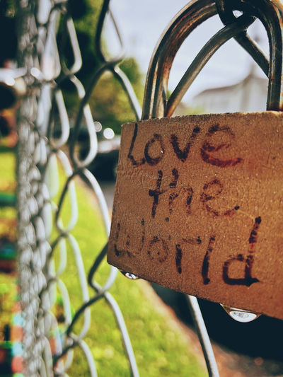 Close-up of padlocks hanging on metal fence