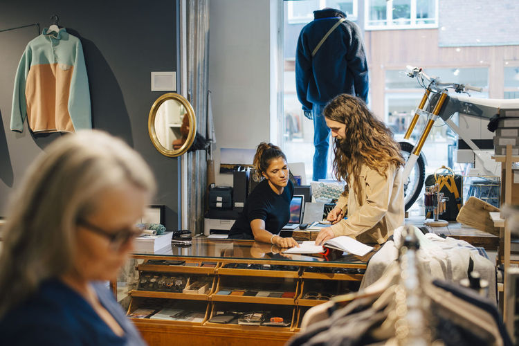 Female and male colleagues discussing in clothing store