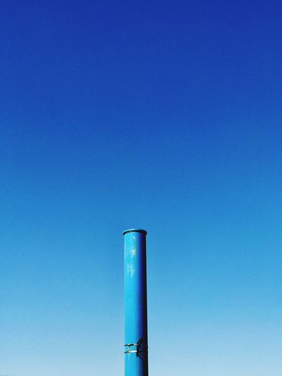 Low angle view of smoke stack against blue sky