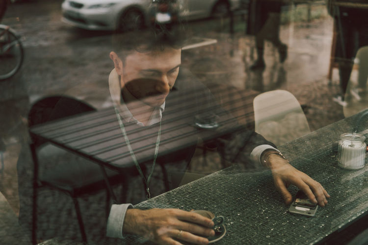 Close-up of young man smoking cigarette on table