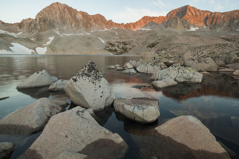 Rocks by lake against mountain range