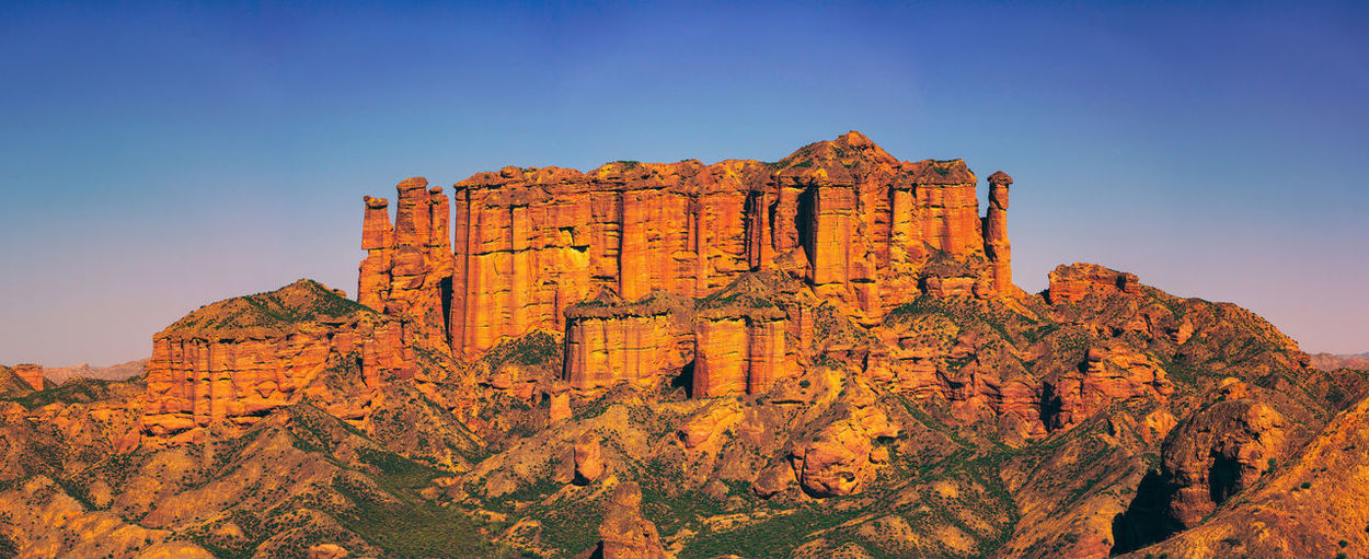 View of rock formation on mountain against blue sky