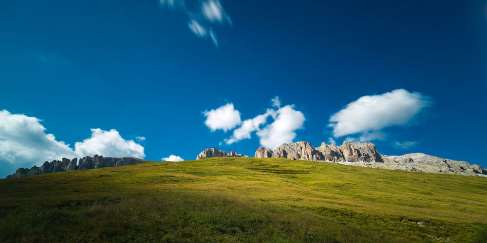 Scenic view of grassy field and mountains against sky