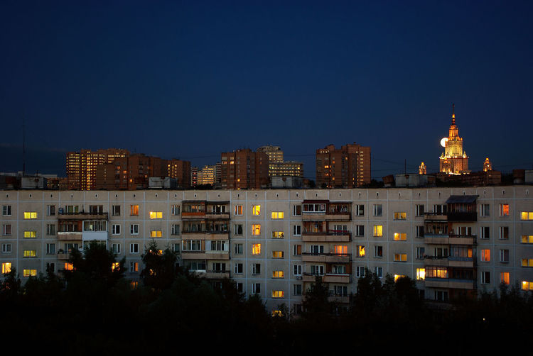 Night view of the round house in moscow, with moon and moscow state univercity at the background