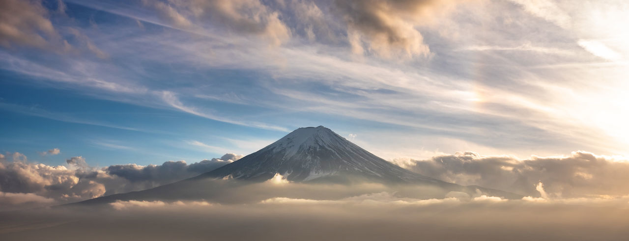 Scenic view of snowcapped mountains against cloudy sky