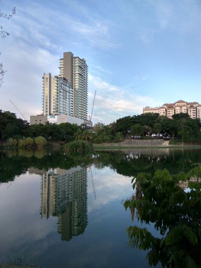 Scenic view of lake by city against sky