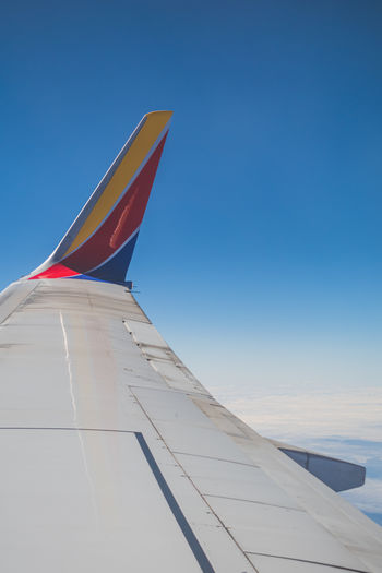 Airplane wing against clear blue sky