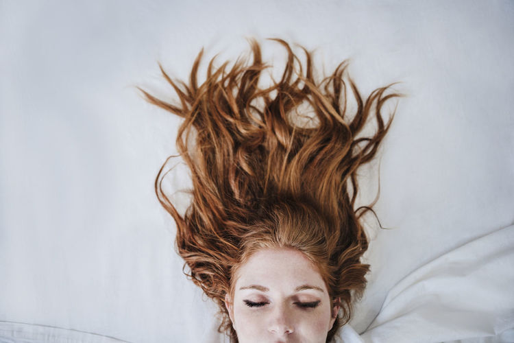 Redhead woman sleeping on bed