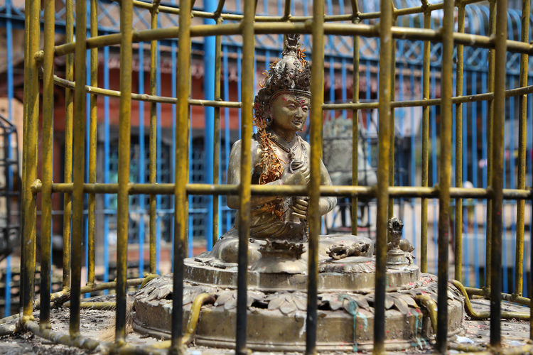 Statue in cage at buddhist temple