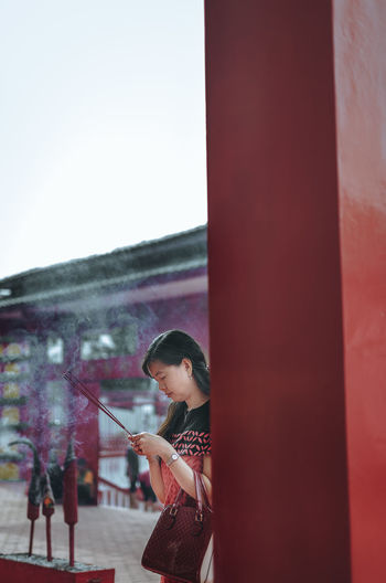 Woman holding incenses at temple