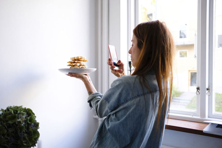 Side view of woman holding food at home