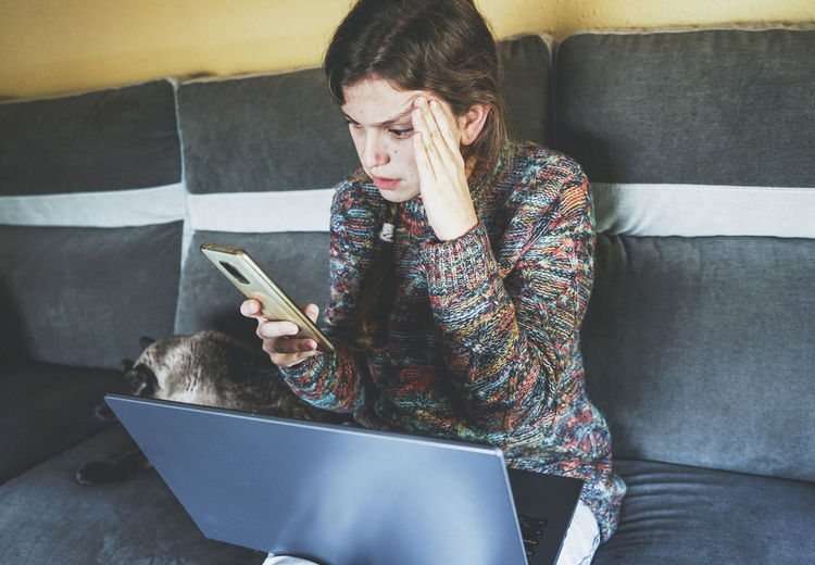 Woman with head in hand looking at smart phone