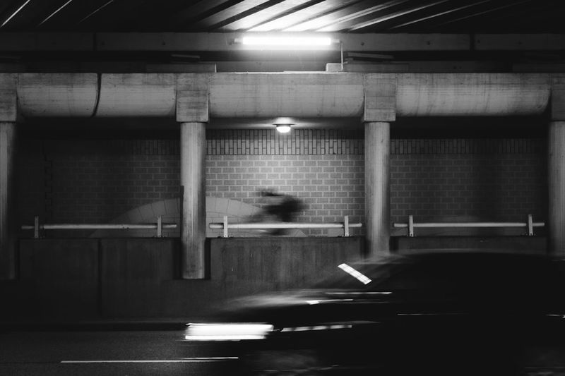 Blurred motion of man walking in illuminated parking lot