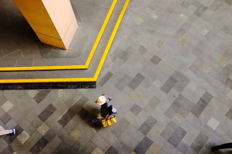High angle view of man sitting on tiled floor