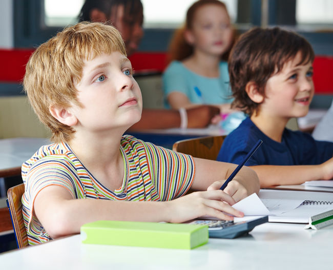 Children listening while sitting at desk in classroom