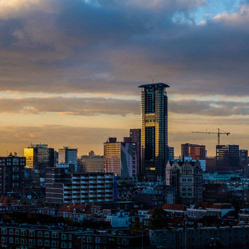 View of cityscape against cloudy sky during sunset