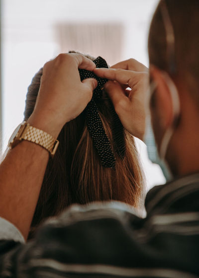 Close-up of man doing a hair bow to a woman