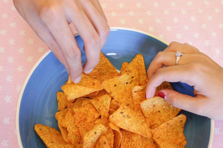Cropped hands holding nachos