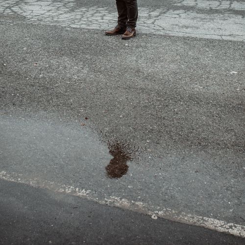 Low section of person standing in puddle