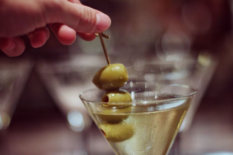 Cropped hand holding green olives