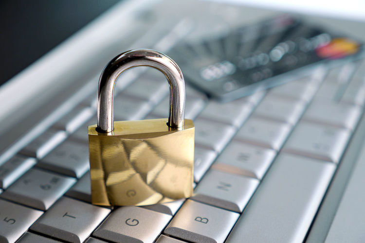 High angle view of padlock and credit card on keyboard