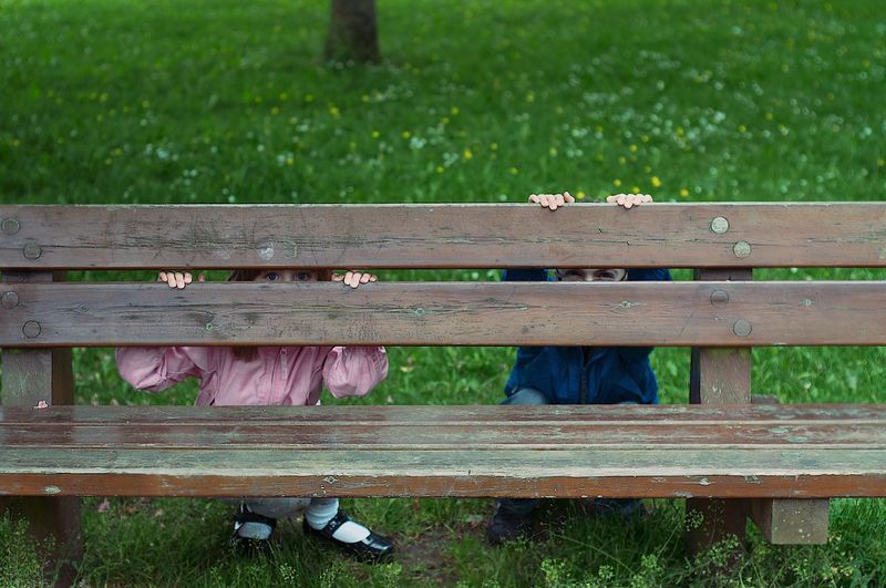 Children in park behind bench 