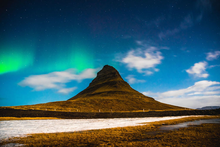 Scenic view of kirkjufell mountain against night sky with aurora borealis