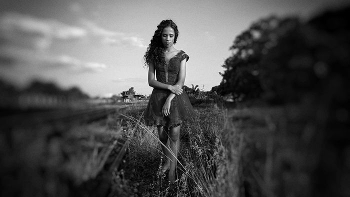 Young woman walking on field against sky