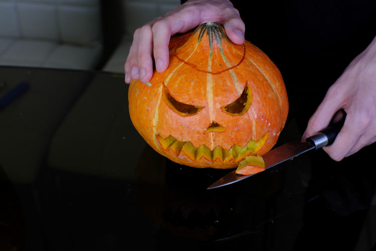 Midsection of person holding pumpkin during halloween