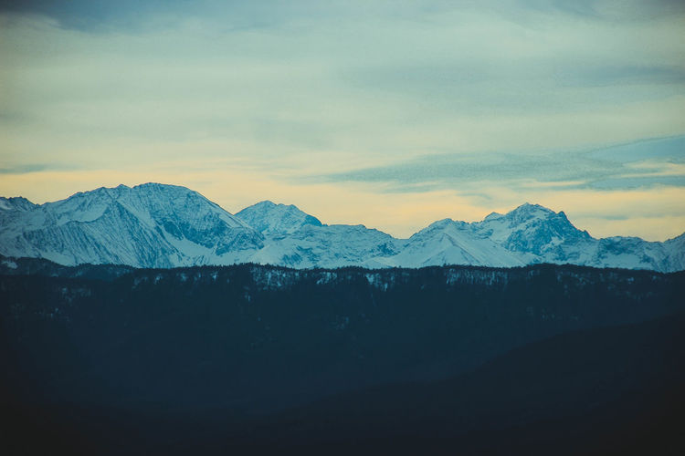 Scenic view of snowcapped mountains against sky during sunset