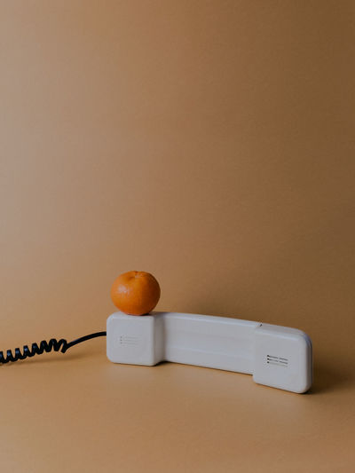 Close-up of orange fruit on table against wall