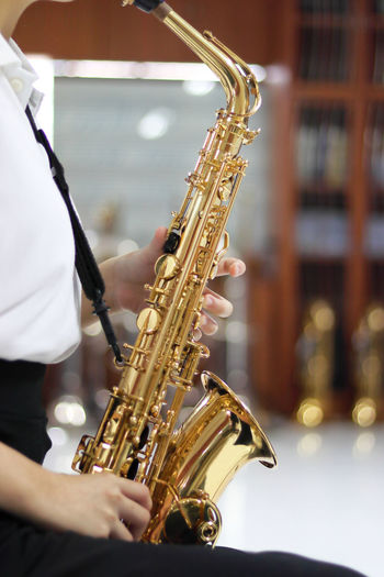 Midsection of woman playing saxophone at music concert