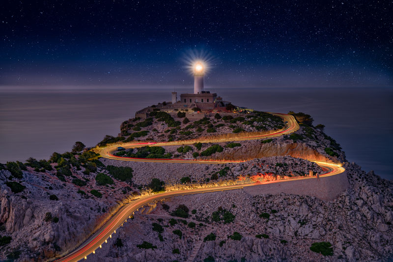 Scenic view of sea against sky at night mountain and lighthouse