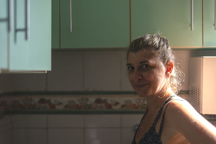 Caucasian woman in the kitchen looking at the camera. 