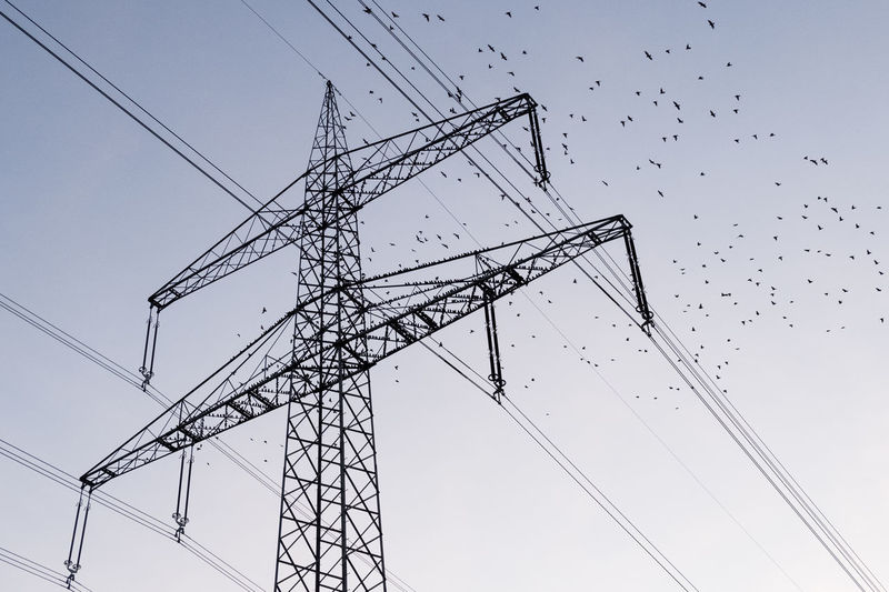 Low angle view of electricity pylon against clear sky