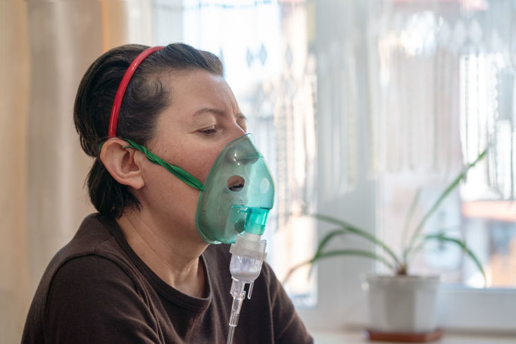 Woman using an inhalation mask at home